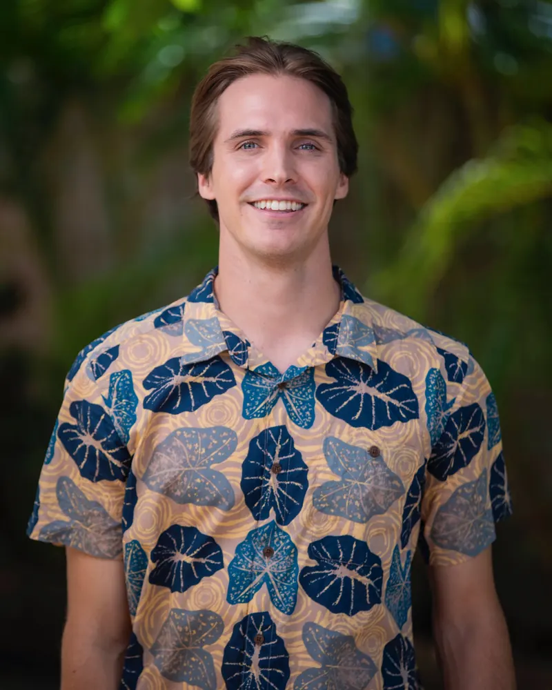 Ben Eberhart in a patterned aloha shirt, in front of tropical foliage